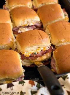 several ham sliders on a plate with a knife in the foreground and text overlay that reads, mississpii sin ham sliders