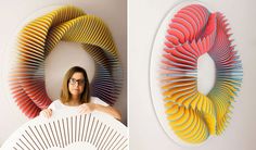 a woman standing in front of a colorful wall sculpture