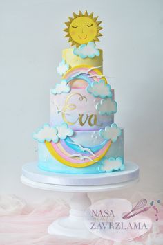 a multi - tiered cake with clouds, sun and stars on top is decorated in pastel colors