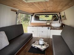 the interior of a camper with couches and coffee table in front of it