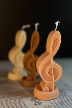 three plastic music notes sitting on top of a newspaper