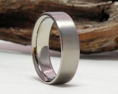 a wedding ring is shown on top of a piece of wood