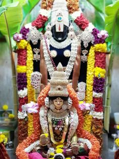 the statue is decorated with flowers and garlands