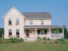 a white house sitting on top of a lush green field