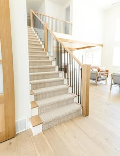 the stairs are made of wood and have carpeted treads on each one side