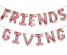 two pink foil balloons that say friends giving and the words friends giving are hanging on a string