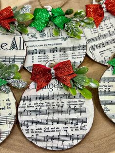 christmas ornaments made out of sheet music with red bows and green glitters on them