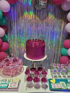 a table topped with a cake and cupcakes