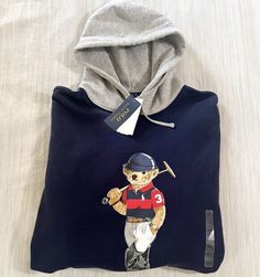 The iconic Polo Bear is ready to play his namesake sport on this cotton-blend hoodie. His uniform is meticulously detailed—from his Polo Ralph Lauren Stirrup watch down to the signature Pony on his Polo shirt. Drawstring hood Long sleeves with ribbed cuffs Polo Bear, "Polo Bear by Ralph Lauren," and "Ralph Lauren" script printed at the center front Ribbed hem Chest LT 52”/XLT 54”/2XLT 59”/2XB 58”/3XLT 64”/3XB 64” Length LT 30”/XLT 32”/2XLT 33” /2XB 31”/3LT 33.5”/3XB 32” Shoulder LT 23”/XLT 24”/2XLT 25”/2XB 25.5”/3XLT 25.5”/3XB 26” Sleeve LT 26.5”/XLT 27”/2XLT 27”/2XB 25”/3XLT 27”/3XB 25” Polo Bear By Ralph Lauren, Ralph Lauren Polo Bear, Polo Bear, Ready To Play, Ralph Lauren Polo, Ralph Lauren Shirt, Big And Tall, Colorful Hoodies, Polo Ralph Lauren Mens