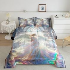 a bed with a colorful comforter on top of it next to a white chair