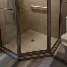 a walk in shower sitting next to a toilet