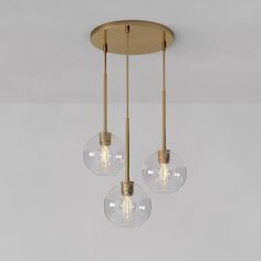 three clear globes hanging from a brass ceiling fixture