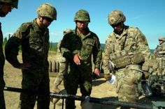 several soldiers are gathered around an object in the dirt