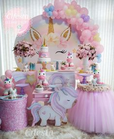 a pink and blue birthday party with unicorns, cake, balloons and other decorations