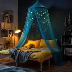 a bed with a blue canopy and stars on the top, in a dark room