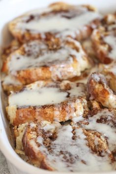 cinnamon rolls with icing in a white dish