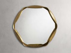 a mirror that is on the wall with a gold ribbon hanging from it's side