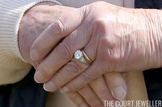 an older woman holding the hand of a younger man who is wearing a diamond ring