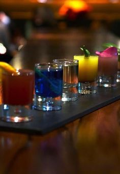 a row of glasses filled with different types of drinks