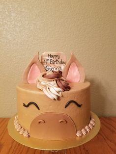 a birthday cake decorated with an animal's face and name on the top layer