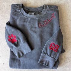 a gray sweatshirt with red paw prints on the front and sleeves that says colley 66