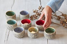 a person placing candles in small bowls on the floor