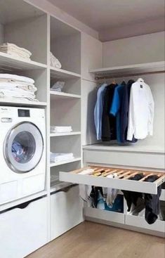 a washer and dryer in a room with white cabinets, drawers and shelves