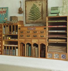 there are many bookshelves and drawers in this room with pictures on the wall