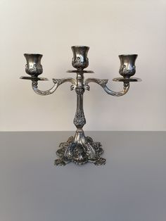 two silver candlesticks sitting on top of a table