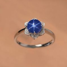 "Most Welcome to \"TheJewelryArts\" Products Description Center Stone: Genuine Lindy Star Sapphire Center Stone Size: 7x7mm Stone Shape: Round Cabochon Side Stone: Cubic Zircon Stone Clarity: VVS Material: 92.5 Sterling Silver, also available in 24k Rose Gold Vermeil/Gold Vermeil/Black Vermeil Stamp: 92.5 ➽OCCASION: Surprise your loved one with this beautiful engagement/wedding jewelry by TheJewelryArts . A classic piece of jewelry for all men/women in your life, this is a perfect gift for any occasion such as birthdays, anniversaries, wedding, engagements, Valentine's Day or Christmas day mother's day. ✔Comfort Fit ✔Nickel Free ✔Free Engraving ✔ Free Shipping ✔  Ready to Ship in 3 Business Day Customization is always welcome and please feel free to contact with me if you have any design i Star Sapphire, Ring Blue, Star Ring, Blue Rings, 925 Sterling Silver Ring, Gold Vermeil, Blue Sapphire, Wedding Engagement, Wedding Jewelry