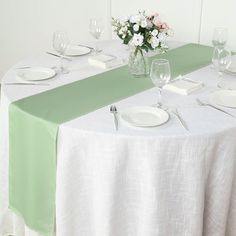 the table is set with white plates and silverware