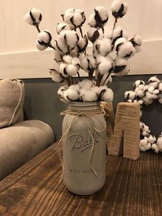 a mason jar filled with cotton sitting on top of a wooden table next to a love sign