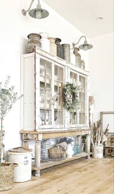 an old fashioned kitchen with white cabinets and wood flooring is featured in this image