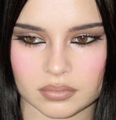 a woman with long black hair and brown eyes is looking at the camera while wearing makeup