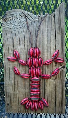 a red string art piece on a wooden fence