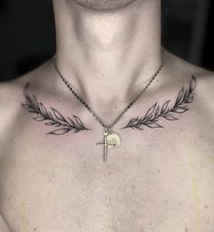 a man with a cross and an arrow tattoo on his chest is wearing a chain