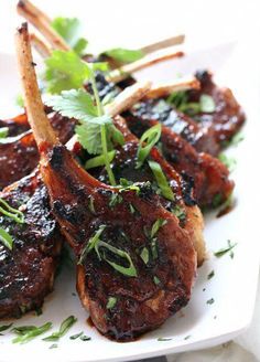 grilled pork chops on a white plate with garnish