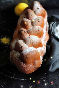 a bundt cake sitting on top of a black plate covered in powdered sugar