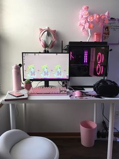 two computer monitors sitting on top of a desk next to a pink cup and vase