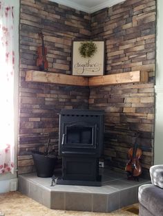 a living room with a wood burning stove in the corner and guitars on the wall