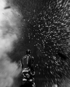 black and white photograph of snowboarder in the air with stars above his head