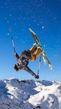 a man flying through the air while riding skis on top of snow covered ground