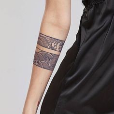 a woman's arm with a tattoo on it and a black dress underneath her