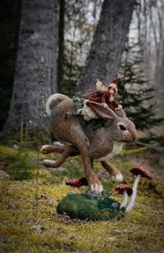 a fairy riding on the back of a rabbit in a forest with mushrooms and trees