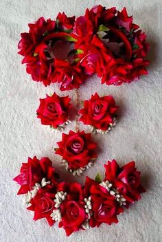 several red roses are arranged on the floor next to each other with pearls in them