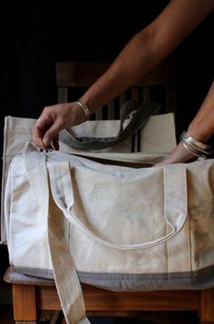 "The WANDER Overnight Bag is made with a natural canvas in 12 oz. Easy to carry but strong enough to hold. I've ensured the notions are strong.  It's a medium sized duffel that will fit a couple days of garments. It can be used as a crossbody as the strap extends up to 57 inches. The bottom of the bag features a gray so you don't have to worry about showing use. Matches the WANDER Tote bag. current color: Coral with natural canvas.  Shown with the 24 OZ. Wander Bag tote   Details:  12 oz. Cotton Large Cotton Canvas Bag, Beige Cotton Canvas Bag With Top Carry Handle, Rectangular Cotton Duffle Bag With Canvas Lining, Cream Canvas Bag With Top Carry Handle, Large Beige Canvas Bag, Natural Canvas Bag With Adjustable Strap, Rectangular Canvas Weekender Bag With Removable Pouch, Coated Canvas Bag With Detachable Strap For Errands, Beige Canvas Duffle Bag Tote