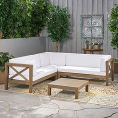 an outdoor living area with wooden furniture and potted plants