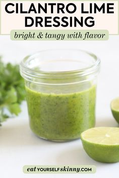 cilantro lime dressing in a glass jar next to sliced limes