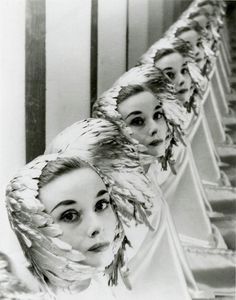 three women with feathers on their heads are lined up in a row and one woman is looking at the camera