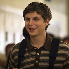 a smiling young man in a striped shirt and suspenders